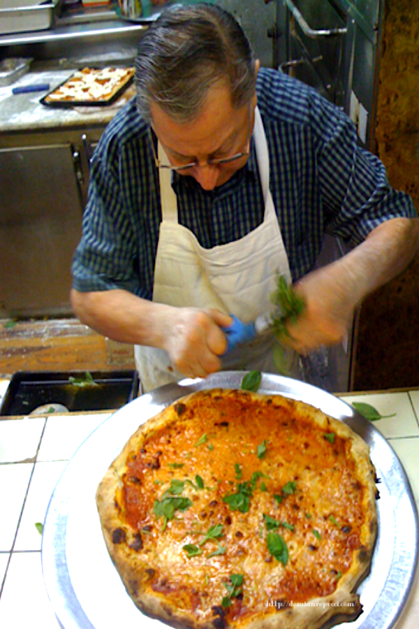 alt= "Di Fara Pizza with Don DeMarco creating handmade pizza pies, a delicious treat for an introvert traveler." demianrepucci.com/