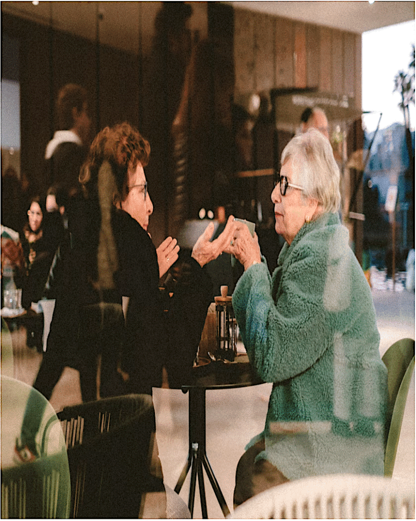 alt="Two Women At A Cafe Discussing Midlife"